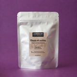 Envase Doypack plateado de Canela en Astillas Amman Tea Blends con propiedades antiinflamatorias y digestivas, sobre fondo morado.