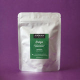 Envase Doypack plateado de Ortiga Amman Tea Blends con etiqueta verde, antiinflamatoria y depurativa, sobre fondo morado.